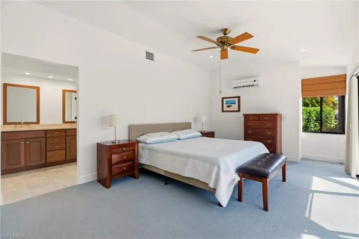Bedroom featuring connected bathroom, light carpet, a ceiling fan, recessed lighting, and lofted ceiling