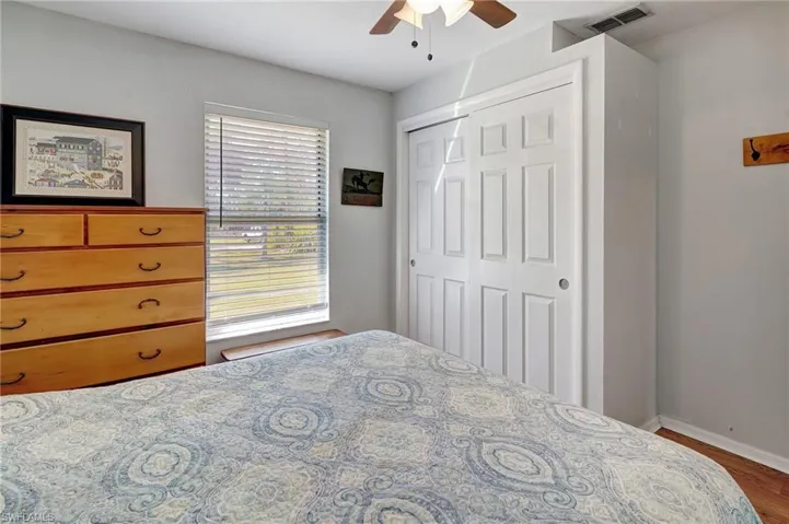 Bedroom with wood finished floors, ceiling fan, and a closet