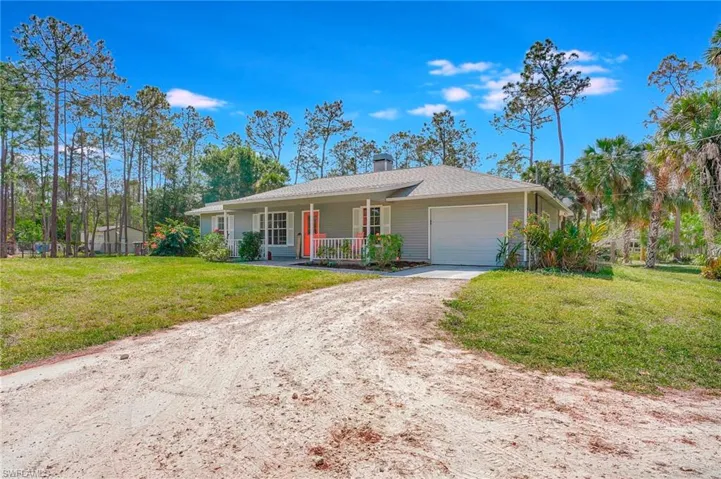Single story home featuring covered porch, a chimney, front lawn and garage