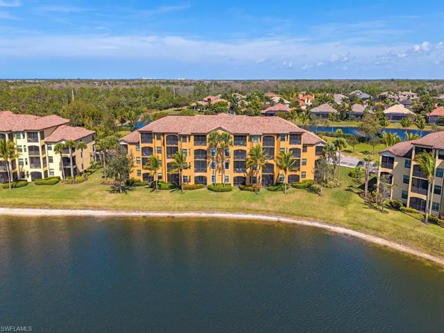 Drone / aerial view of a nearby body of water and apartment complex / building