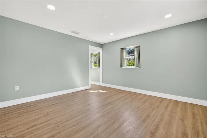 Unfurnished room with wood finished floors and recessed lighting