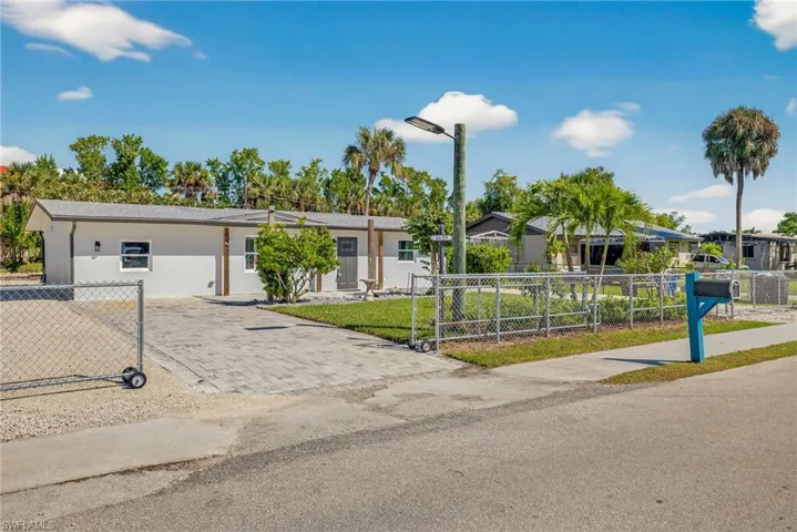Single story home featuring a gate, driveway, and stucco siding