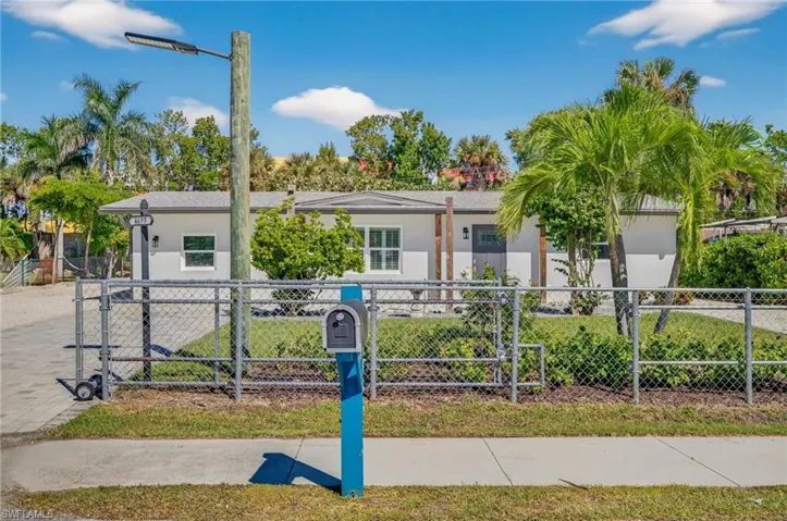 View of front of property with a fenced front yard, stucco siding, and a gate