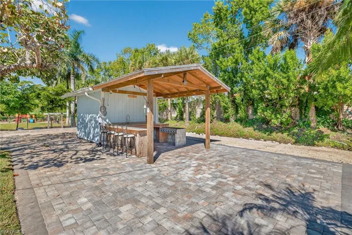 View of patio with area for grilling and a carport