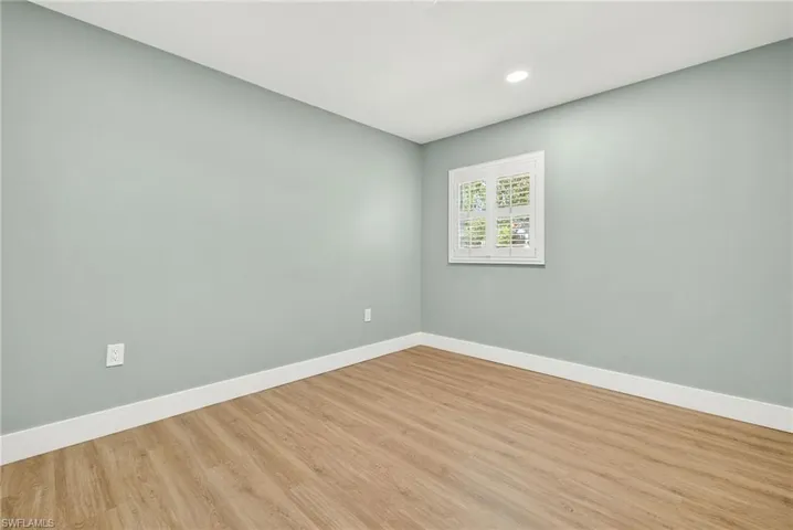 Unfurnished room with wood finished floors and recessed lighting