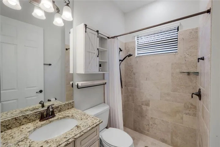 Guest bathroom with walk-in shower with corner shelf and window allowing natural light to flow through!