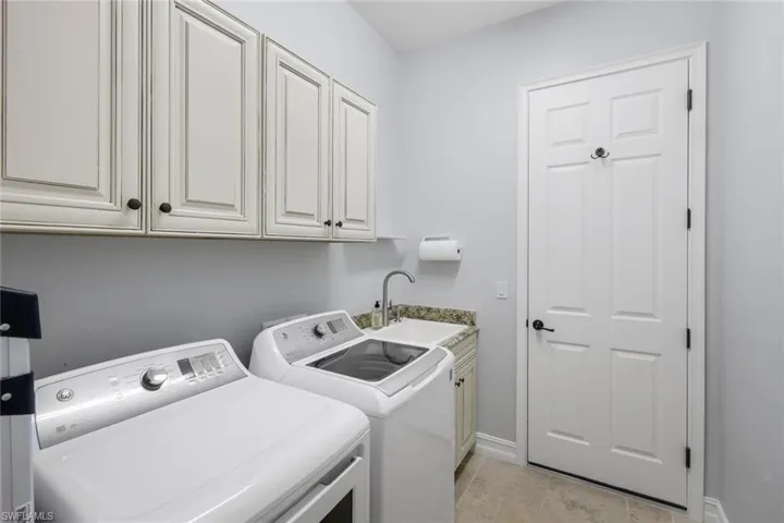 Utility Room Complete with upper cabinets and utility sink with lower cabinets for storage!