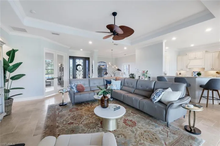 Light and bright living area with tray ceiling and crown molding. French doors leading to your Den!