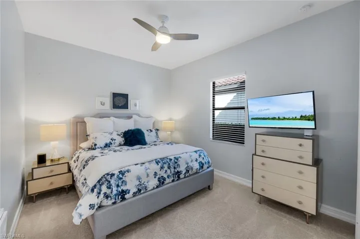 Guest bedroom #1 with ceiling fan/light and window.