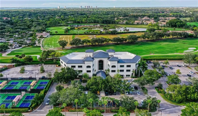 Drone / aerial view of a golf course and a nearby body of water