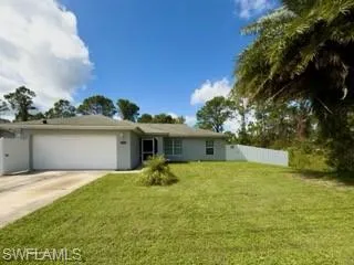 Ranch-style home featuring a front lawn and a garage