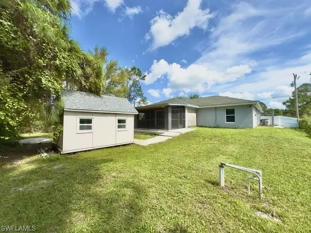 Rear view of house with a yard and a sunroom