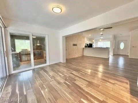 Unfurnished living room with wood-type flooring, plenty of natural light, and ceiling fan