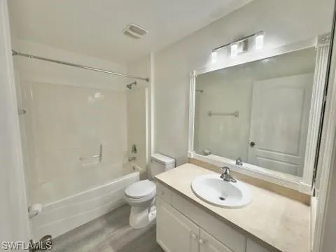 Full bathroom featuring toilet, hardwood / wood-style floors, vanity, and shower / bath combination