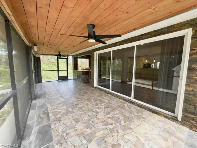 Unfurnished sunroom featuring ceiling fan and wood ceiling