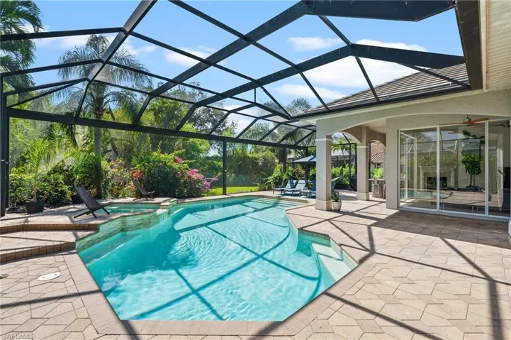 View of pool featuring ceiling fan, a patio area, and glass enclosure