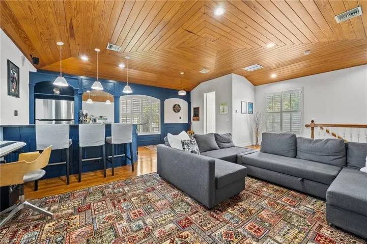 Living room featuring vaulted ceiling, wood-type flooring, and wood ceiling