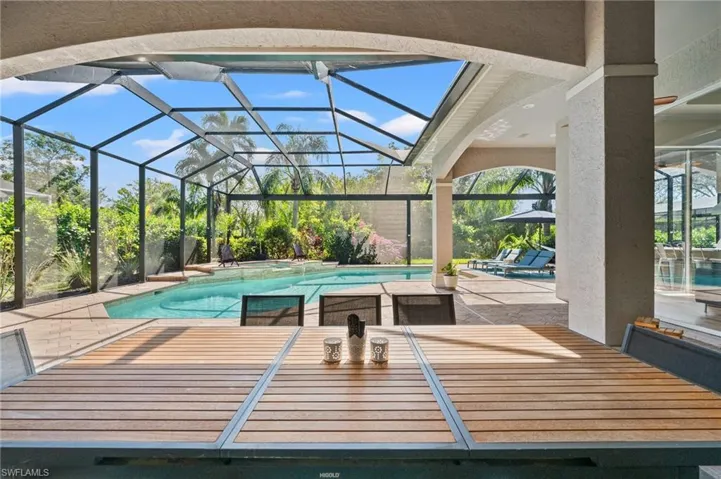 View of swimming pool featuring a lanai and a patio area