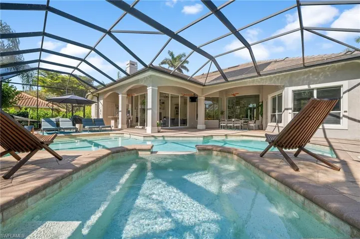 View of swimming pool featuring ceiling fan, an outdoor living space, a patio area, and glass enclosure