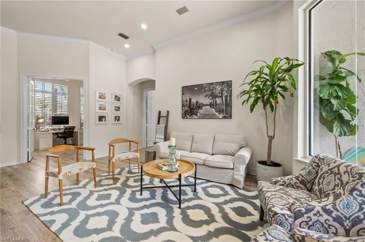 Living room with ornamental molding and light wood-type flooring