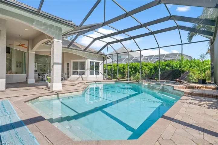View of swimming pool with a patio, a lanai, and ceiling fan