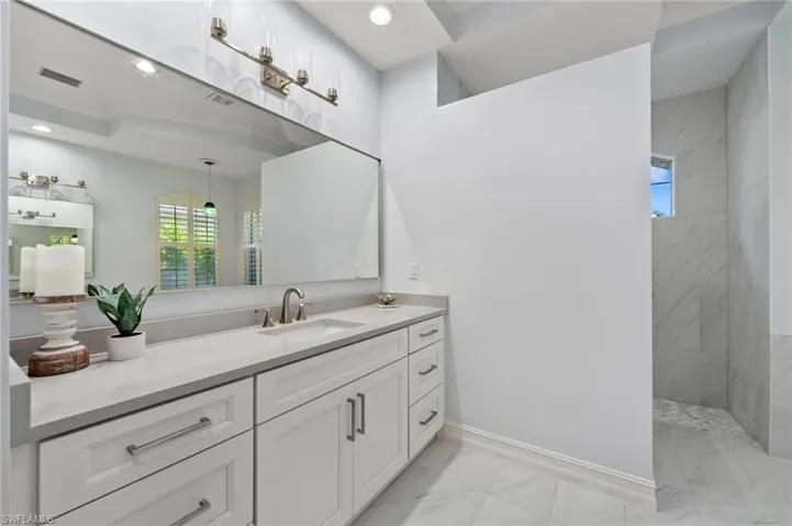 Bathroom featuring vanity and tiled shower