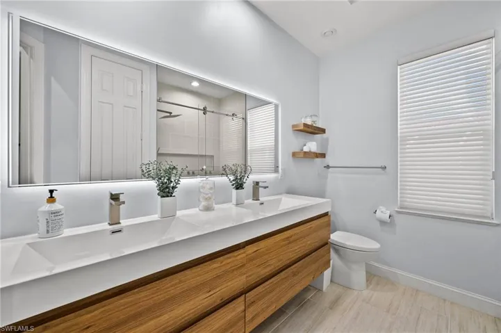 Bathroom with vanity, toilet, and a shower with door