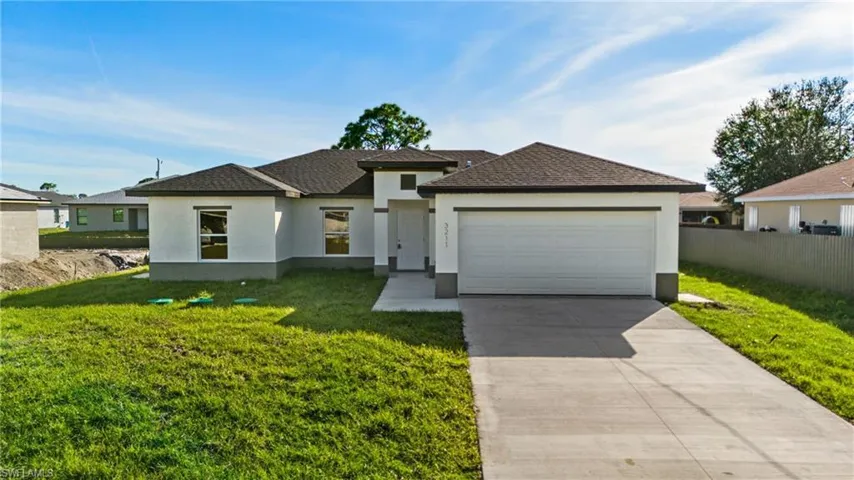 View of front of house featuring a garage and a front lawn