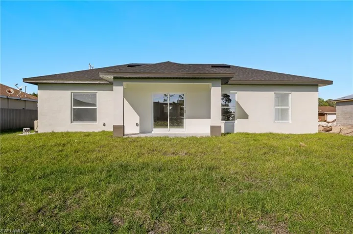 Rear view of house with a yard