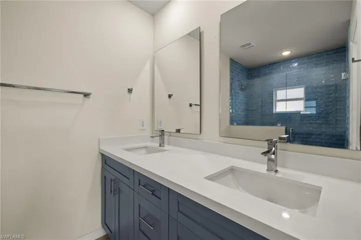 Bathroom with tiled shower and vanity