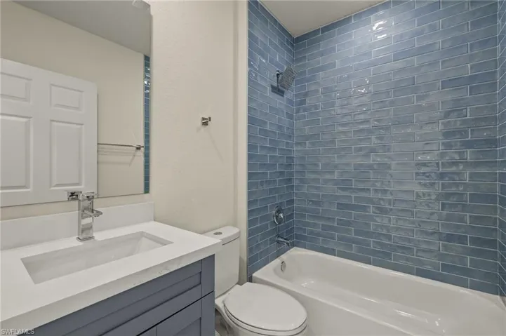 Full bathroom with toilet, vanity, and tiled shower / bath