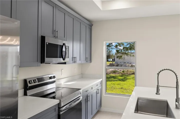 Kitchen with sink, appliances with stainless steel finishes, and gray cabinets