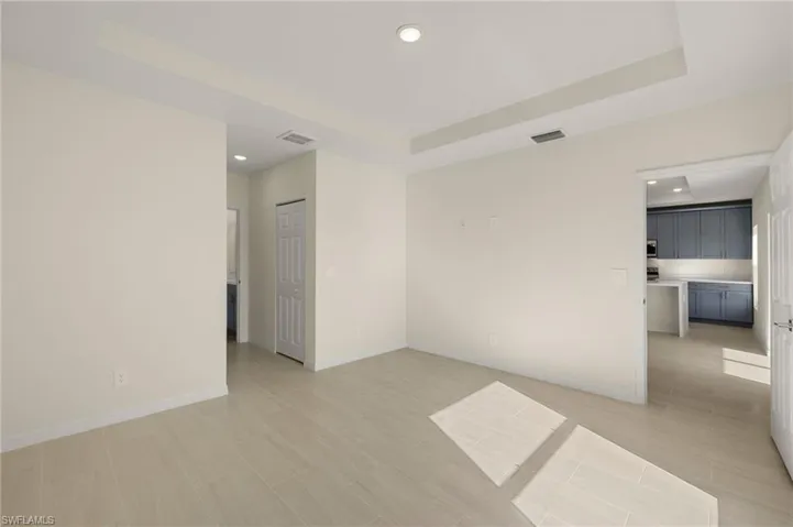 Tiled spare room featuring a raised ceiling