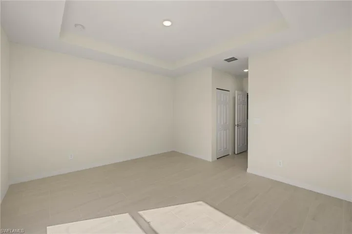 Unfurnished room with a tray ceiling