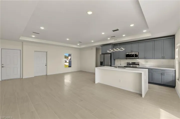 Kitchen with sink, appliances with stainless steel finishes, gray cabinets, and a raised ceiling