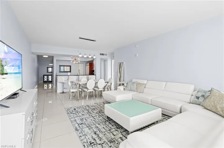Living area with light tile patterned floors and a chandelier