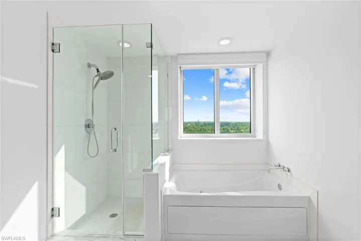 Bathroom featuring a shower stall and a bath