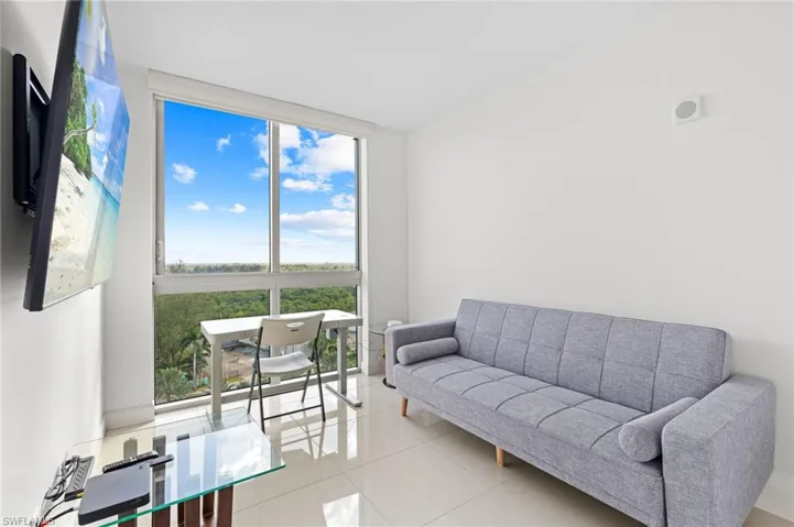 Living area with floor to ceiling windows and light tile patterned floors