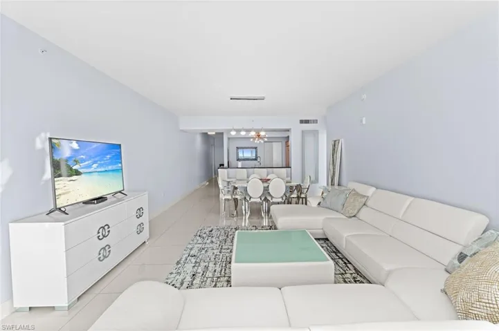 Living area featuring light tile patterned floors and suspended lighting