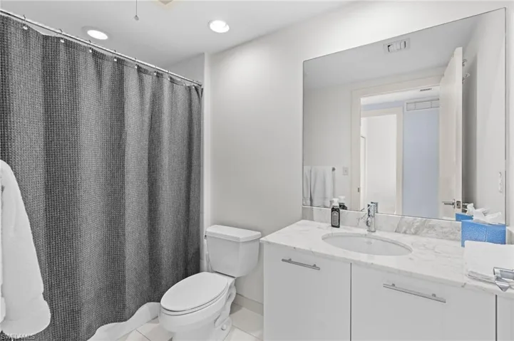 Full bathroom featuring vanity, curtained shower, and recessed lighting