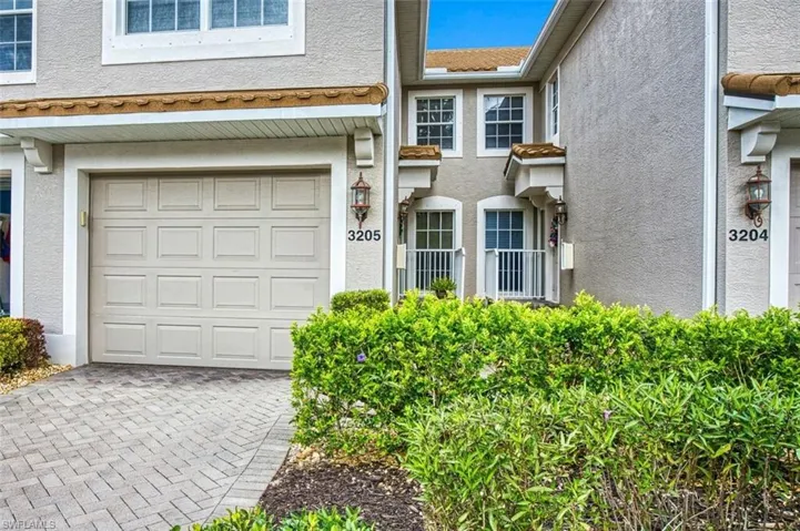 Doorway to property featuring stucco siding and a garage