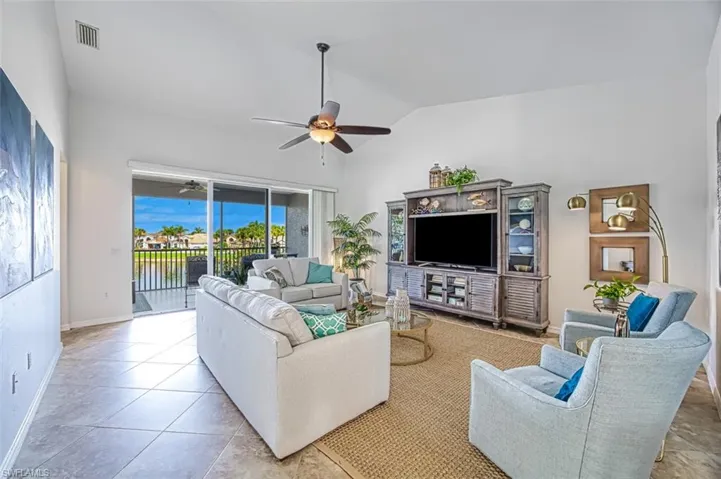 Tiled living area featuring lofted ceiling and a ceiling fan
