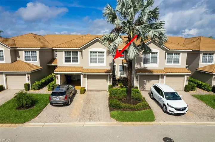 View of front of house featuring a residential view, stucco siding, a tiled roof, and driveway