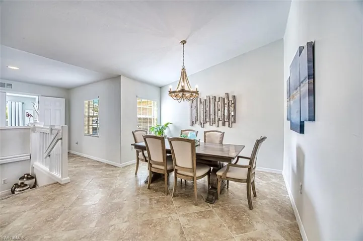 Dining space featuring a chandelier, vaulted ceiling, and light tile patterned floors