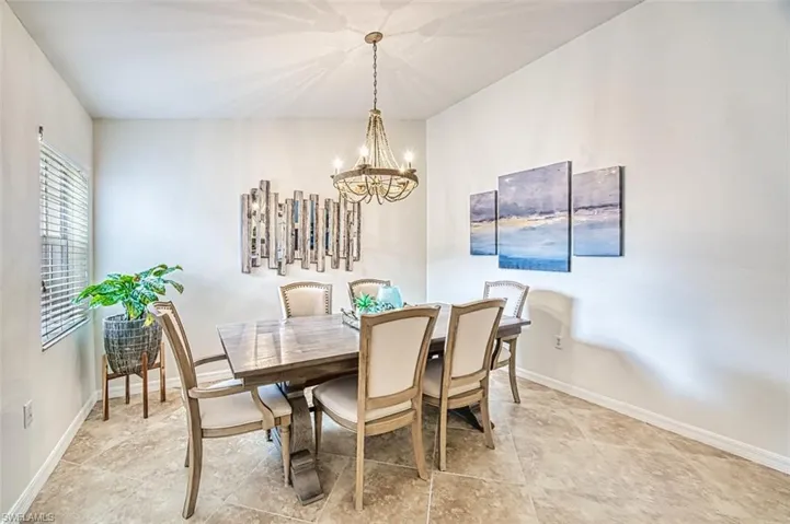 Dining space with a chandelier and baseboards