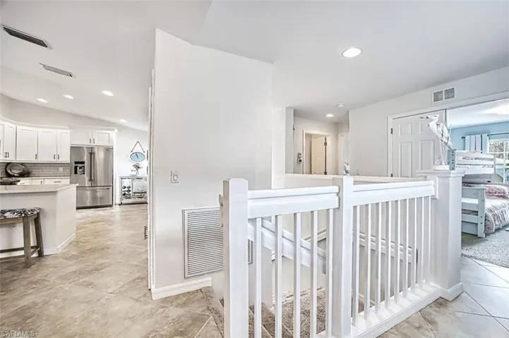 Corridor featuring an upstairs landing, recessed lighting, and light tile patterned flooring