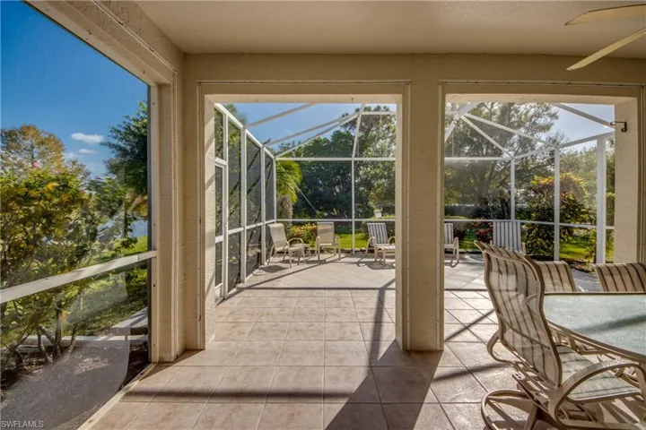 Screened-in lanai featuring tile flooring, ceiling fan, and structural enclosure