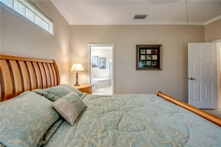 Neutral wall tones, horizontal transom window, crown molding, and white six-panel interior door