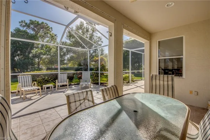 Screen-enclosed lanai featuring a covered patio, neutral tile flooring, and recessed ceiling lighting