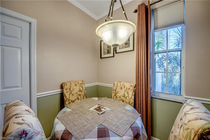Multi-pane window with cellular shade, chair rail molding, and decorative bowl-style pendant light